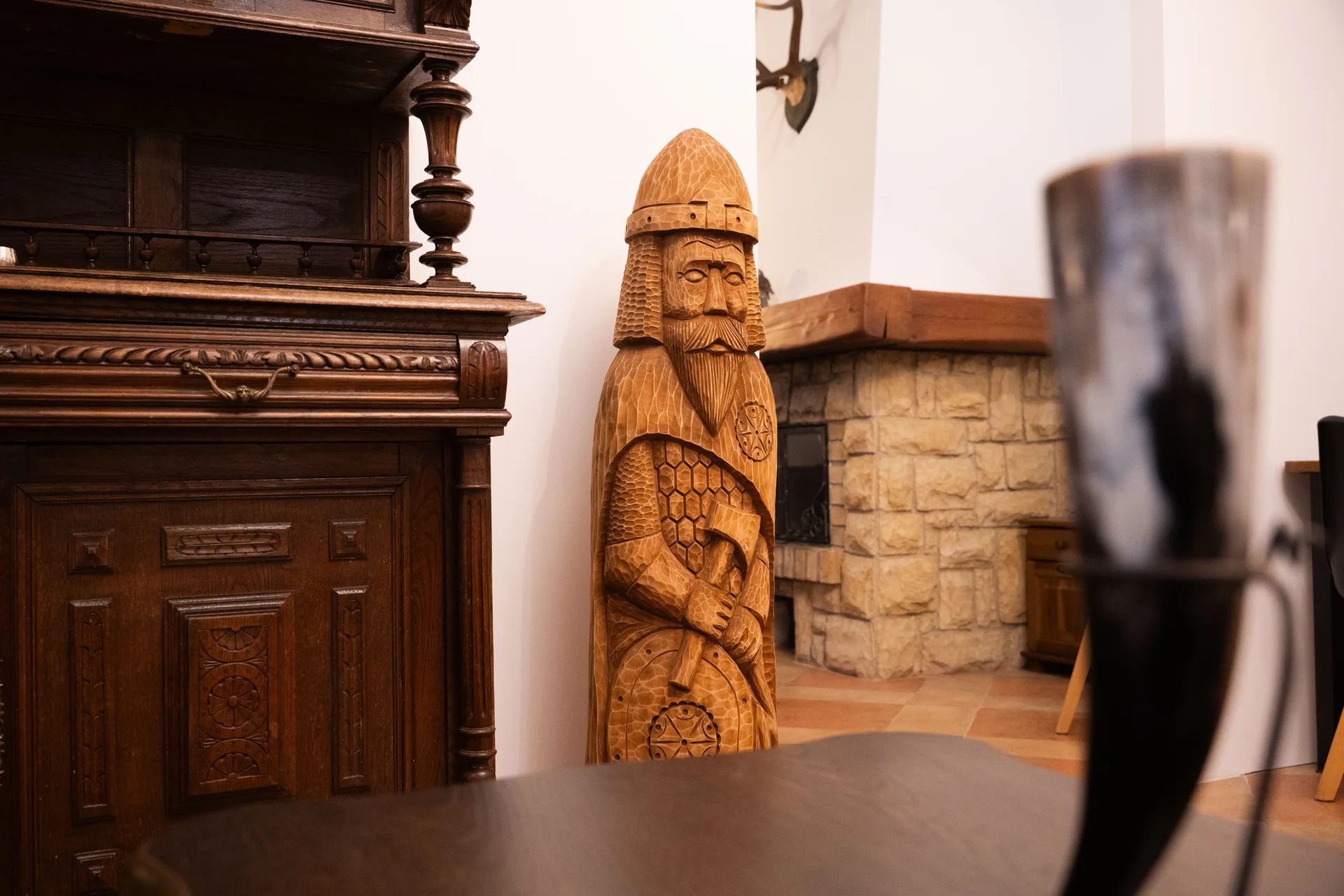 Perun figure carved in wood, beside antique furniture